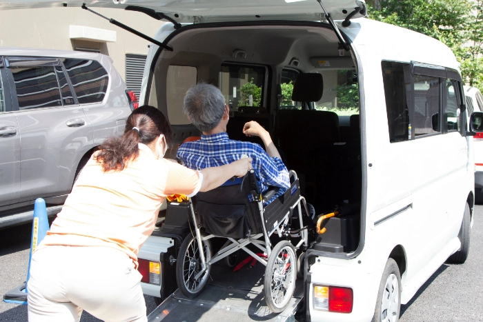 車椅子に乗っている人を車に乗せる人